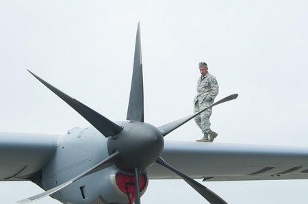 US Air Force mechanic inspects the engine of a giant C-130 aircraft